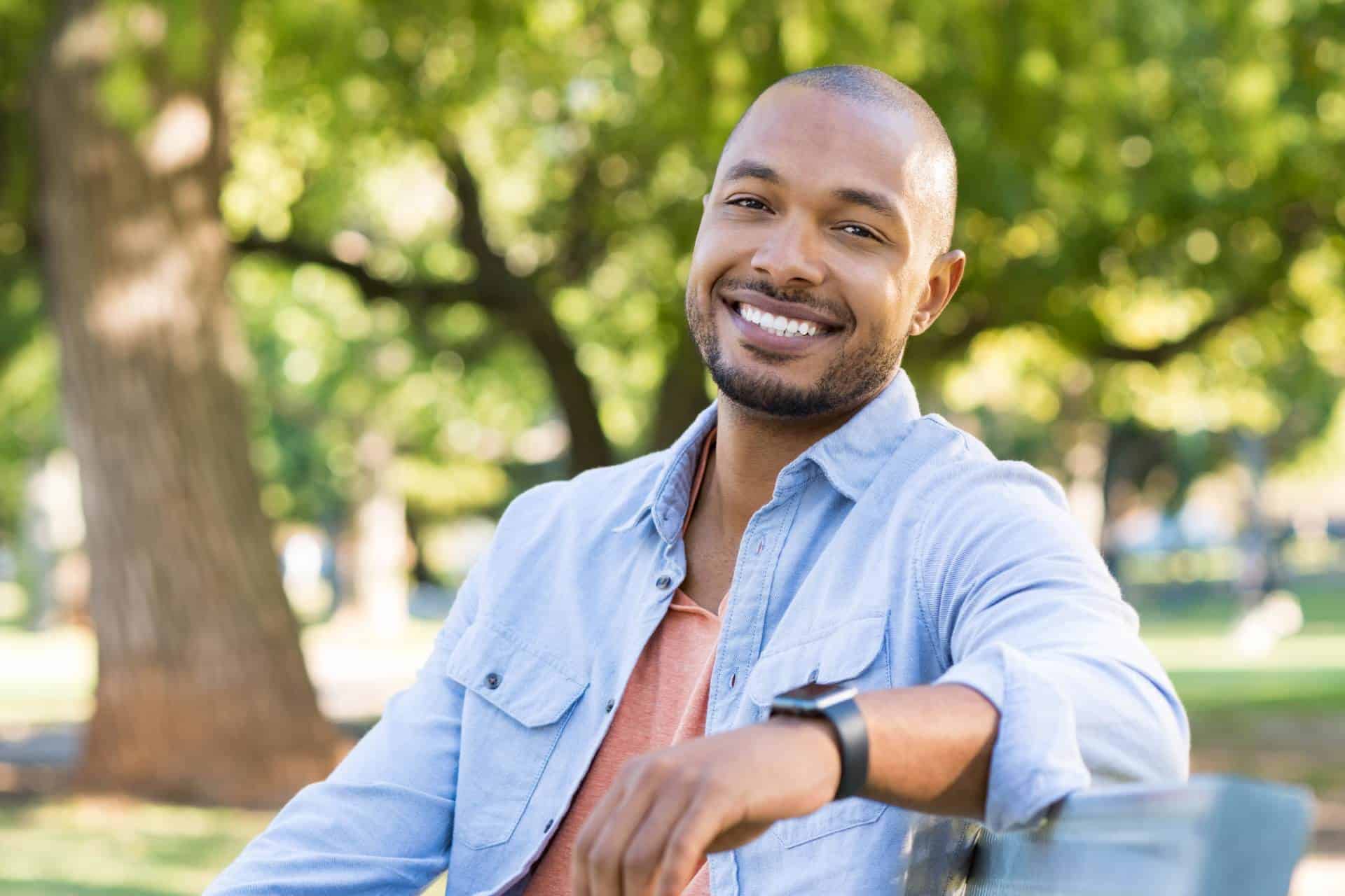 Man smiling in a park after orthodontic care from Farina Orthodontics in Tampa, FL. 