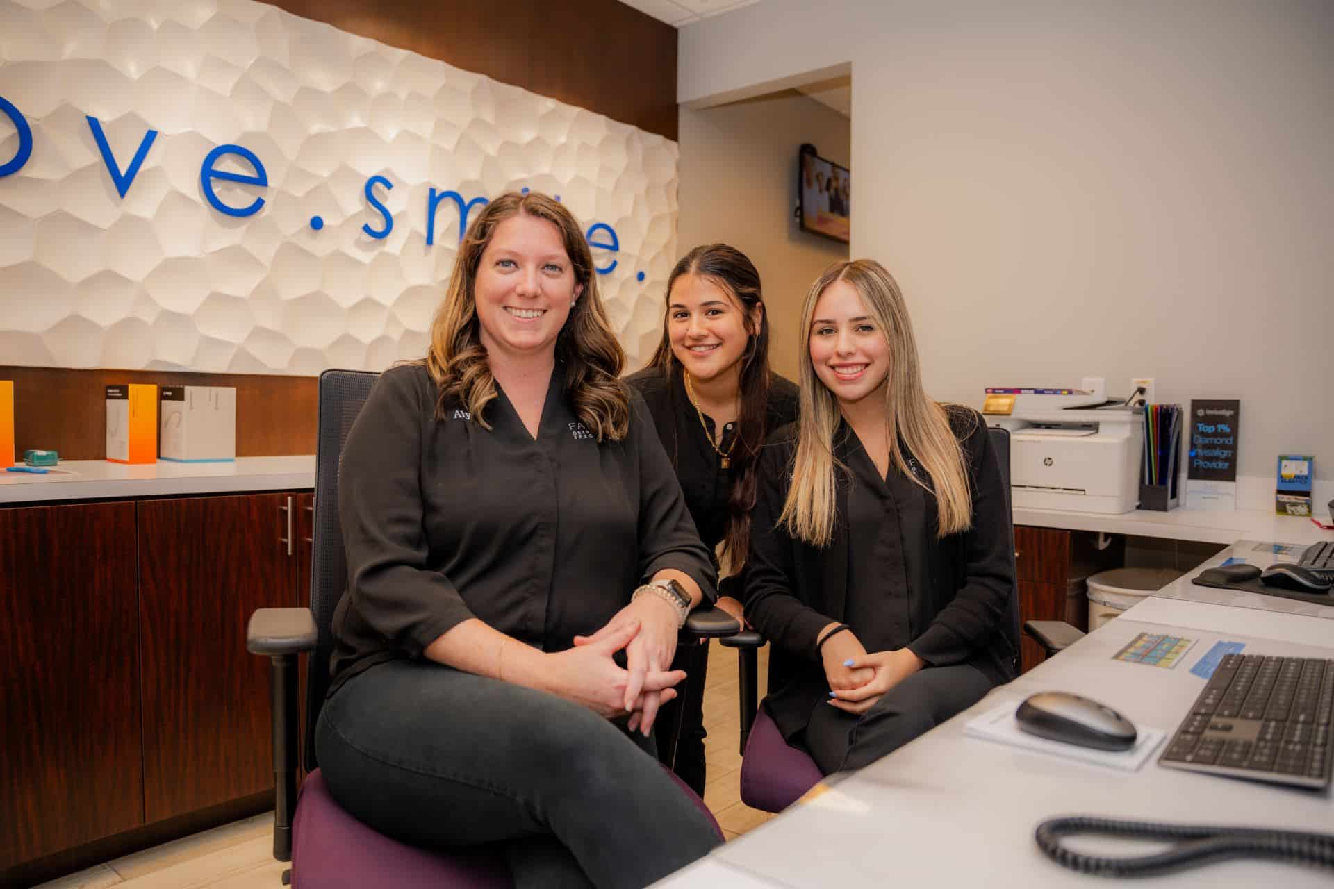 Staff at Farina Orthodontics smiling at the front desk.